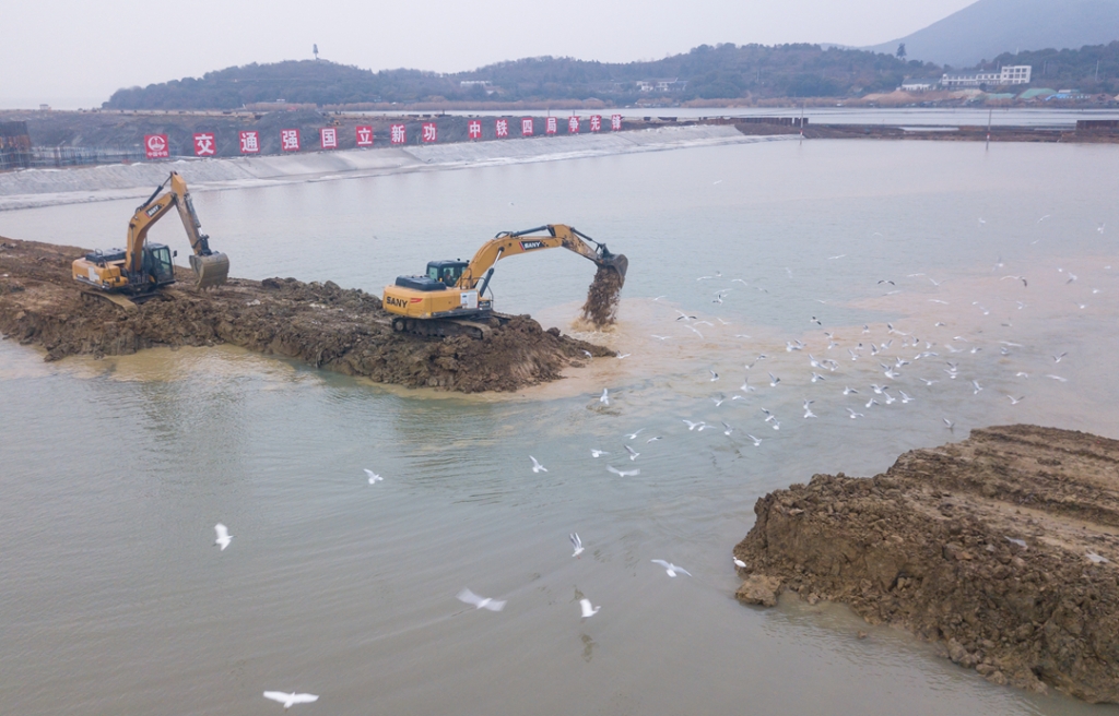 2019年12月23日，鳥群從陸島轉(zhuǎn)換圍堰回水施工現(xiàn)場飛過。